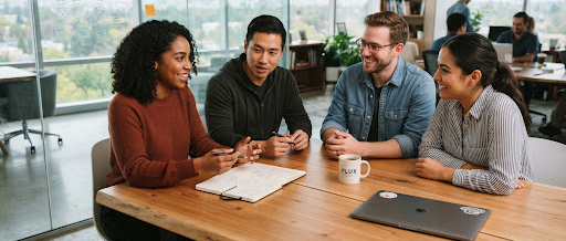 Team collaborating around a laptop